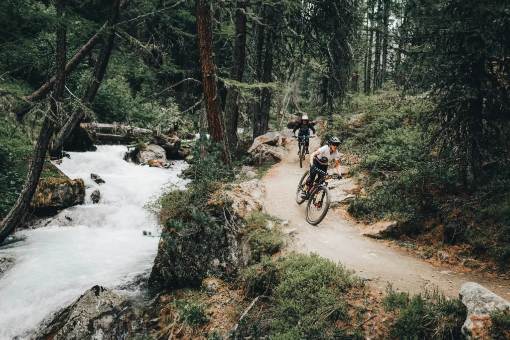Due rider lungo un torrente di montagna